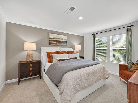 Relax and unwind after a long day in the spacious primary bedroom.