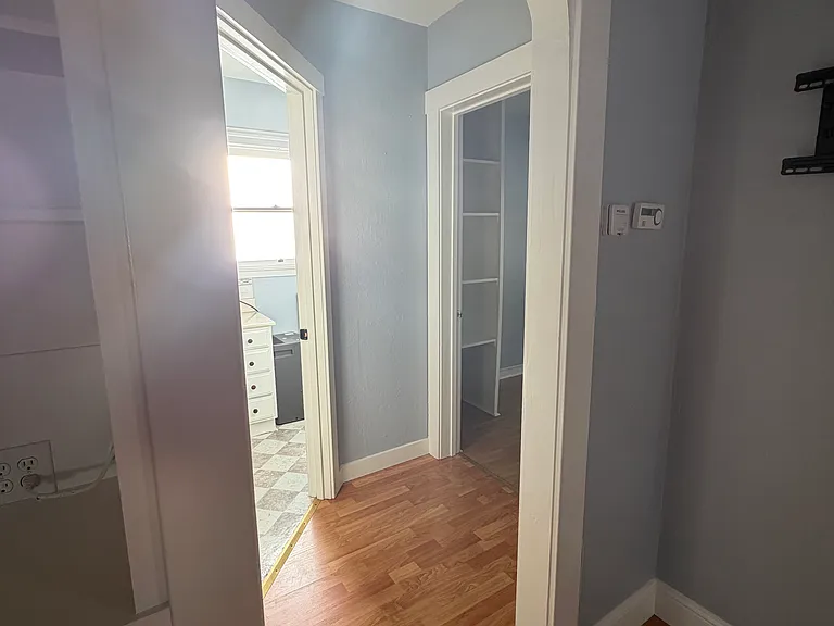 A hallway from the living room leads to the bathroom and upstairs bedroom.