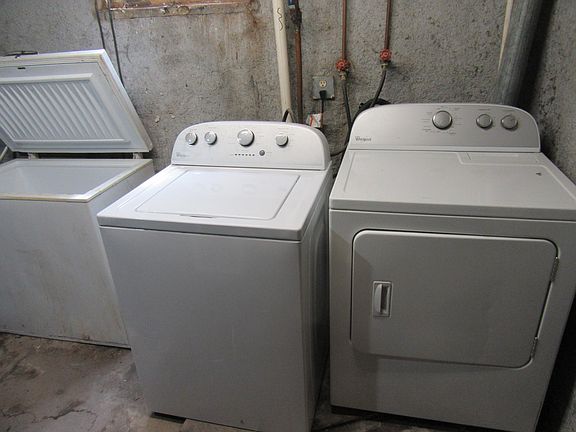 laundry facilities and freezer in unfinished basement