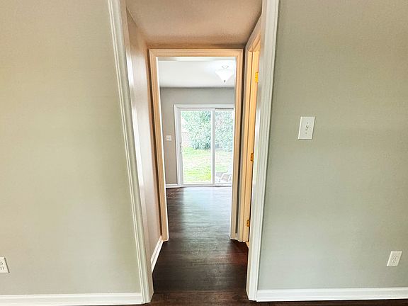 Hallway joining living space to dining/kitchen. Half bath in hallway.