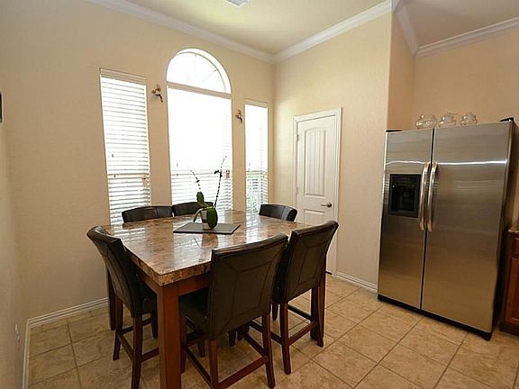 Breakfast room highlighted by raised ceilings, tile floors and opens to the kitchen.