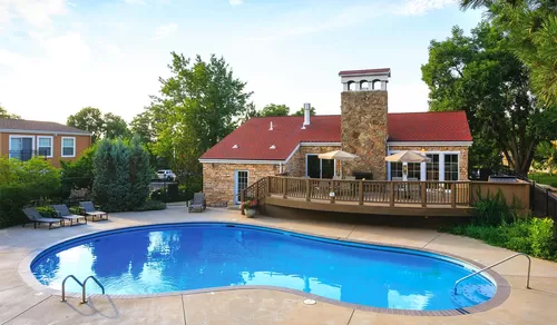Outdoor swimming pool with lounge chairs - Boulder Creek Apartments