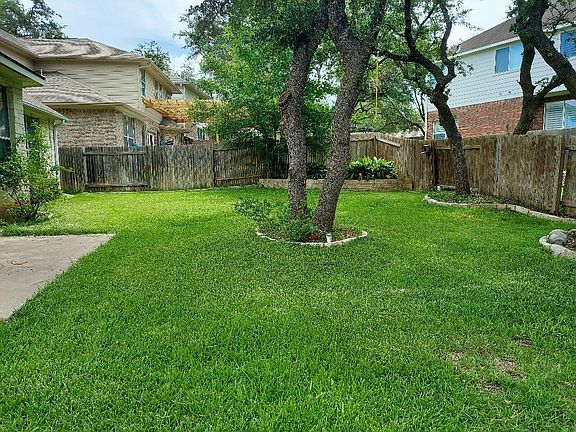NICE TREE SHADED BACK YARD WITH LARGE PATIO OF KITCHEN