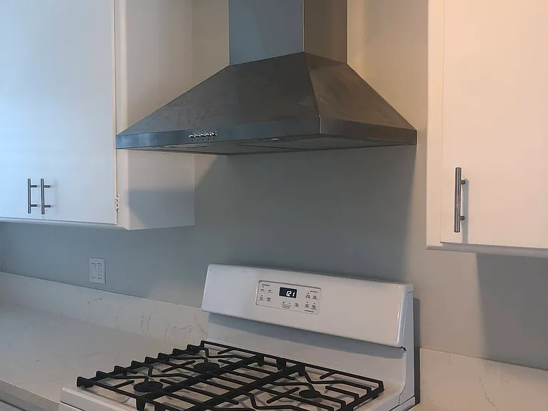 Charming kitchen with gas stove and white cabinets