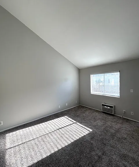Living Room with vaulted ceilings and plenty of natural light and A/C unit