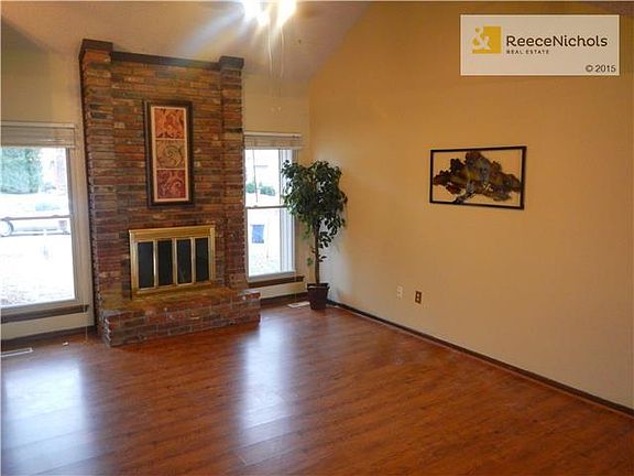 Large great room with fresh paint, new windows, fireplace & vaulted ceiling with fan
