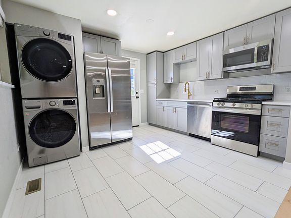 Fully renovated kitchen including brand new stainless steel appliances and a gas stove. The door in back leads to the large private yard.