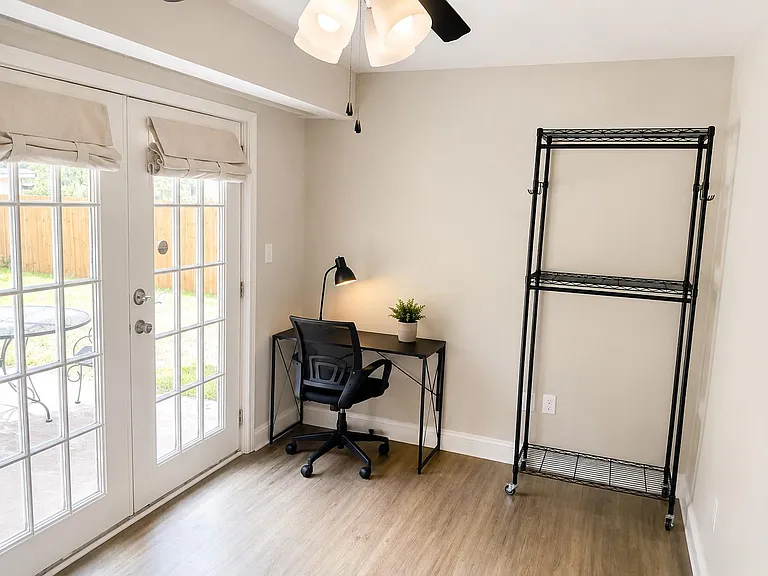 Flexible room with French-door patio access, a dedicated work nook, and open space for storage or multi-purpose use.