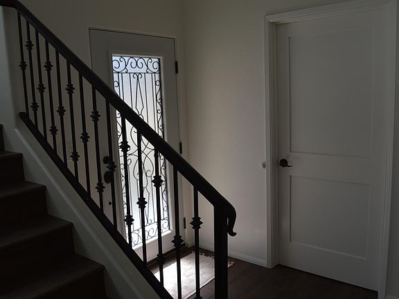 Foyer showing front door, staircase and door to laundry room.