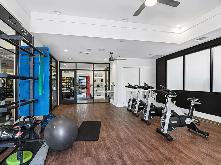 Markethaus 3700 Fitness Studio A gym with a variety of equipment including a stationary bike, a medicine ball, and a weight rack.