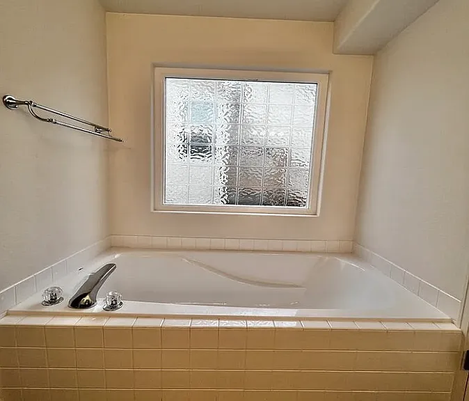 Garden tub as viewed from the dual sink and cabinet area. Shower is on the other side of the wall shown on the left.
