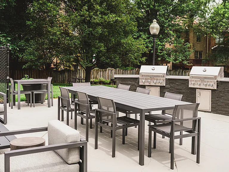 Upgraded outdoor kitchen features state of the art grills, community table and plenty of lounge seating