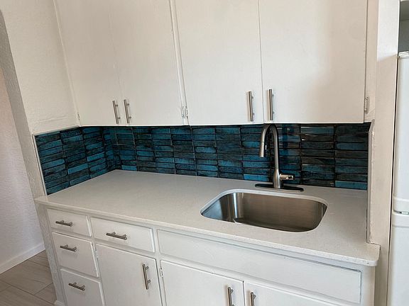 Beautiful blue tiles and quartz countertops.