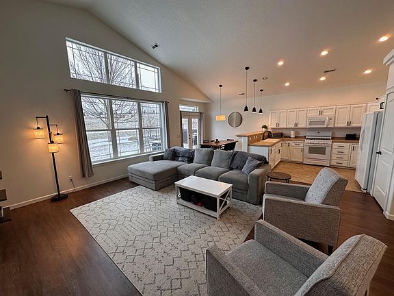 Living room with large windows facing Prairie Falls Golf Course (house does not come furnished, this is just for staging). Beautiful bright view all year.
