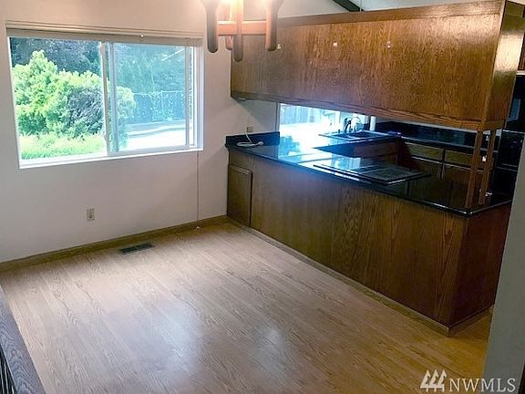 This is the dining room with open sight lines to the kitchen and family room, and a large window overlooking the back yard.