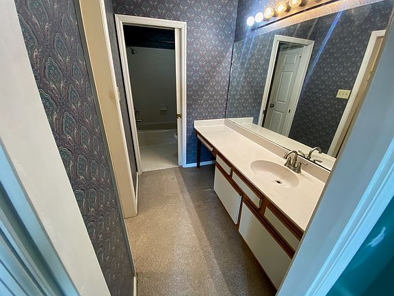 En-suite bathroom with walk-in closet on left and wash closet with shower ahead