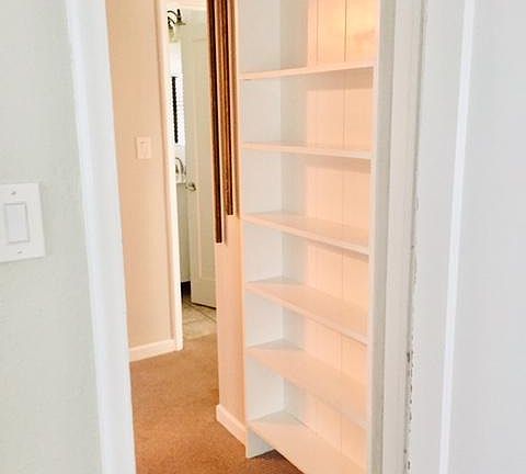 Hall area with built in shelves for books and other items.