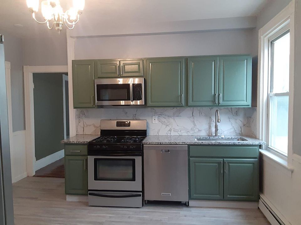 Kitchen includes stainless appliances (stove, dishwasher, microwave) and granite countertops along with brushed nickel pulls and a faucet with pull-down sprayer. side cabinet to be added to left wall to increase cabinet and countertop space