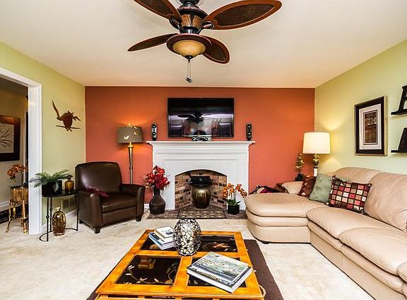 Bright living room w/ neutral carpet & ceiling fan