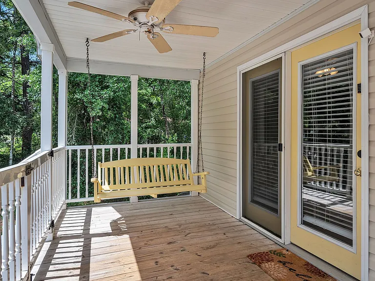 Gated porch with two porch swings and 3 deck chairs. Ceiling fans provide a nice breeze.