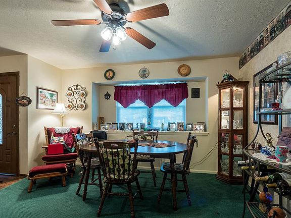 The spacious dining room has a box window and ceiling fan.