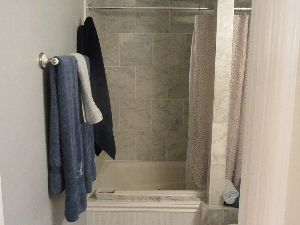 Carrera marble bathroom with jetted tub and pedestal sink.
