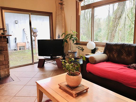 Living room with views of the backyard. Sliding door leads to the patio, deck, backyard and creek. The television works well but there is no cable service. Connects to your laptop or other device. HDMI cable available. Bring your own adapter.