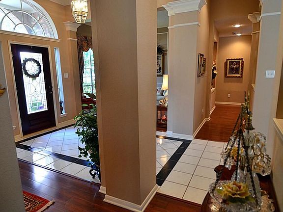 A view of the foyer with the beautiful columns and tiled floors with decorative entry accent.