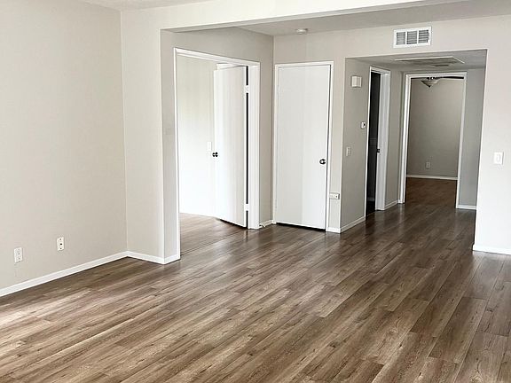 View from living room toward primary bedroom on the left, hall closet, laundry room and 2nd bedroom