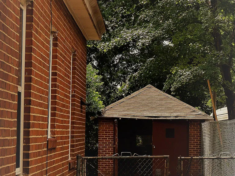 Fenced yard, storage shed off carport.