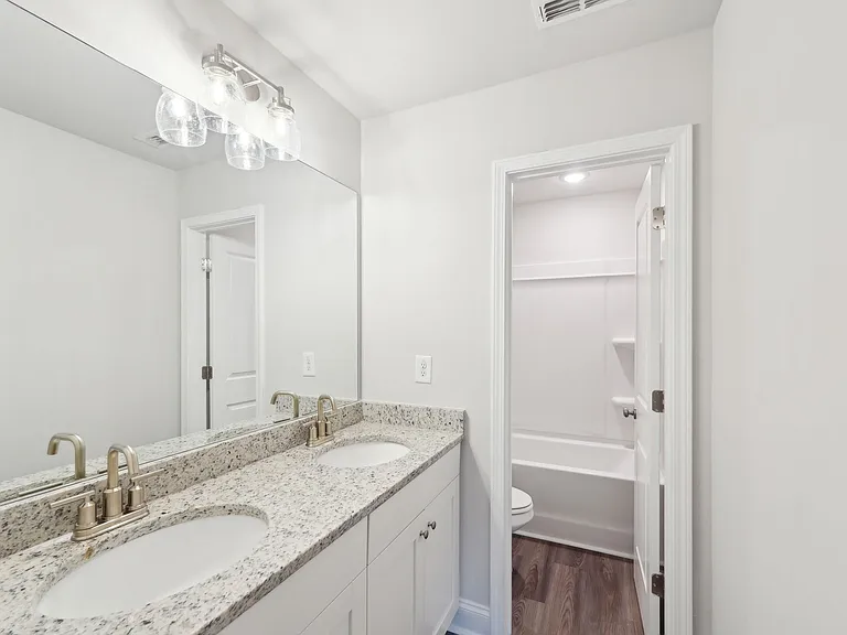 Secondary bathroom with double vanity and tub shower