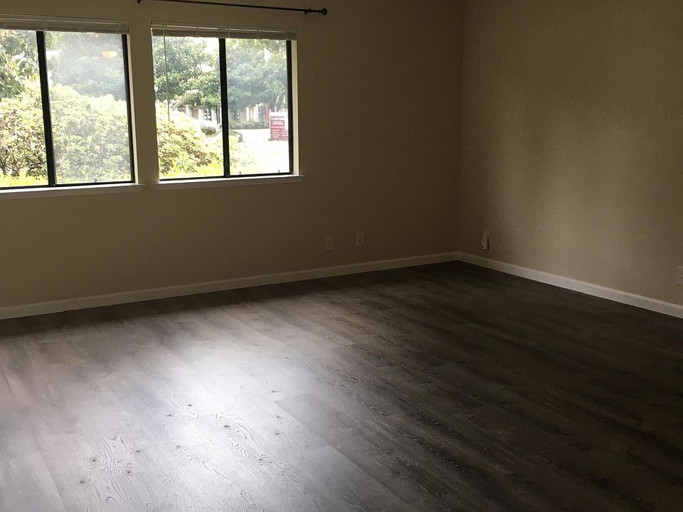 Living room, vinyl plank floors, blinds in windows.