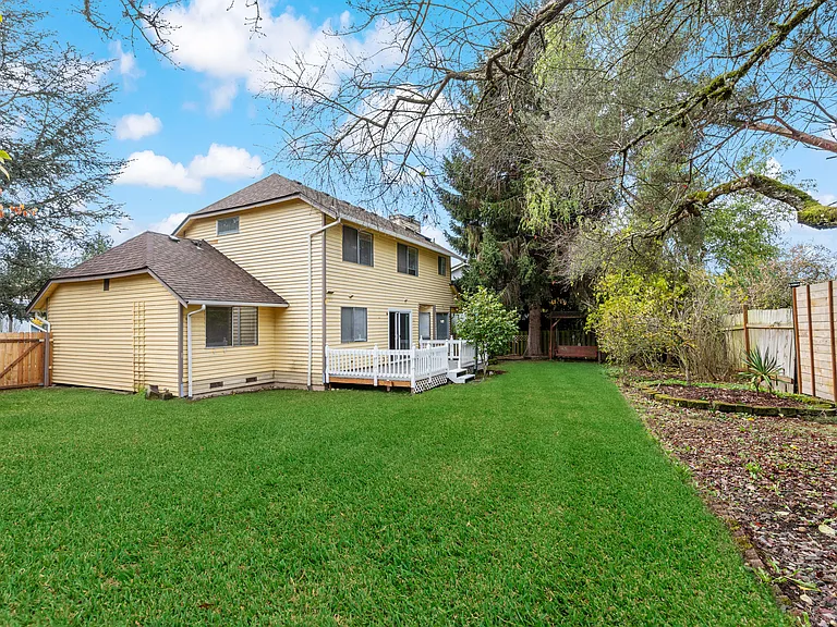 Enjoy a large backyard featuring a well-maintained lawn, beautiful landscaping with mature trees, and full fencing_perfect for outdoor living, play, or entertaining.