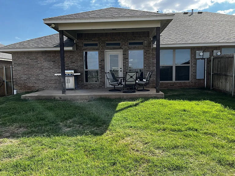 back covered patio with green lawn