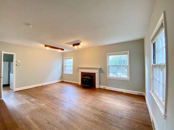 Large main level living room with working wood stove insert in fireplace.