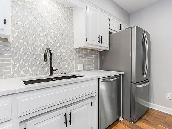 Kitchen with custom tile backsplash, stainless steel appliances and Quartz countertops.