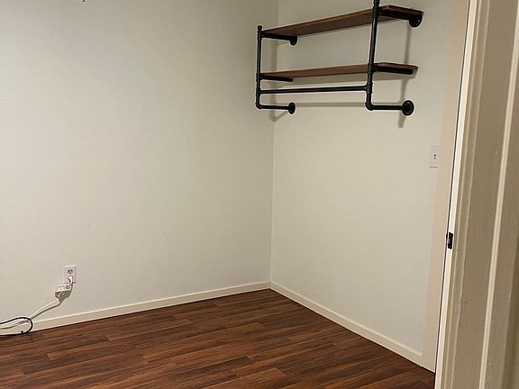 Second bedroom with storage shelving. Small closet behind door with shelves as well.