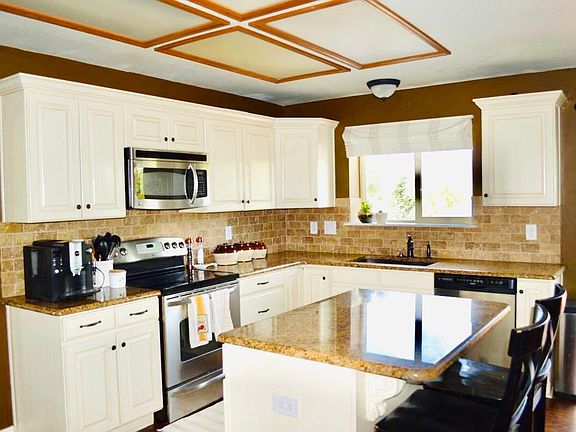 Open-concept kitchen with granite counter tops and stainless steel appliances