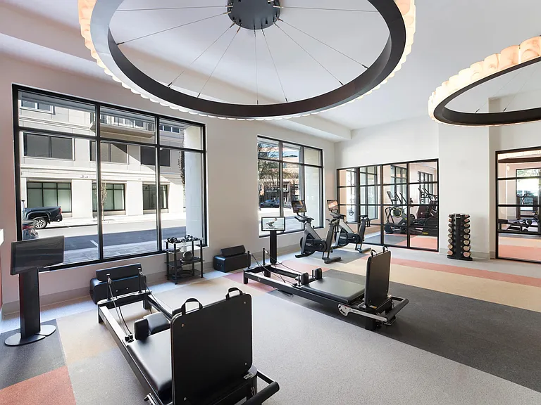 A light-filled fitness studio featuring reformers, bikes, and strength equipment in a flexible layout designed to support a variety of workouts and training styles.