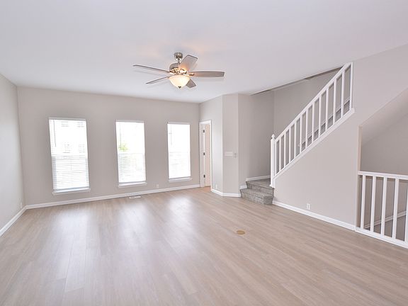 Spacious living room with 9 ft ceilings ceiling fan and LVP flooring