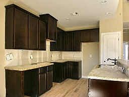 Mocha stained cabinets, granite countertops, 18 inch tile,stainless steel appliances.. open kitchen 