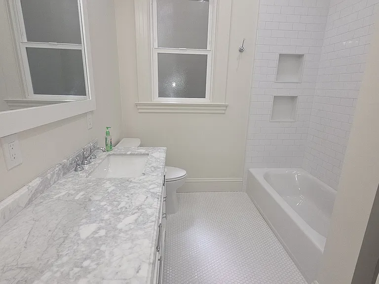 Main bathroom with shower over tub. Double sinks and heated tile floor.