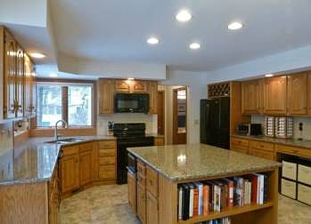 Nice open kitchen with enormous island, newer granite counters, and dura ceramic floors!  At the end of the island is a wonderful 2 shelf bookcase that could be removed if you wish to put a couple bar stools there.