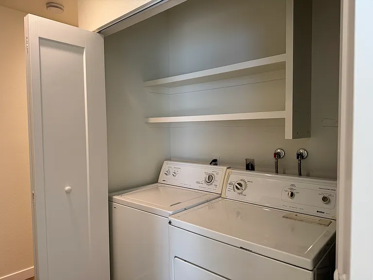Laundry closet with shelving above