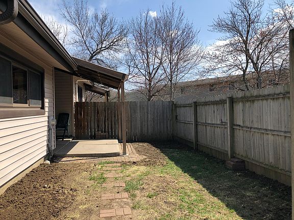 Fenced in backyard with covered patio