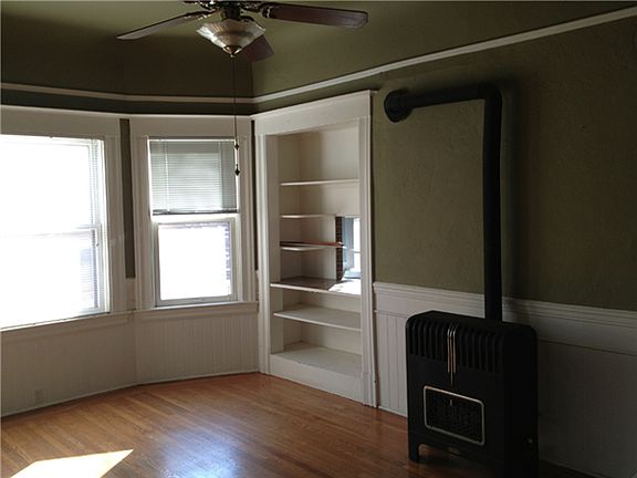 Living room with fireplace and open window to kitchen