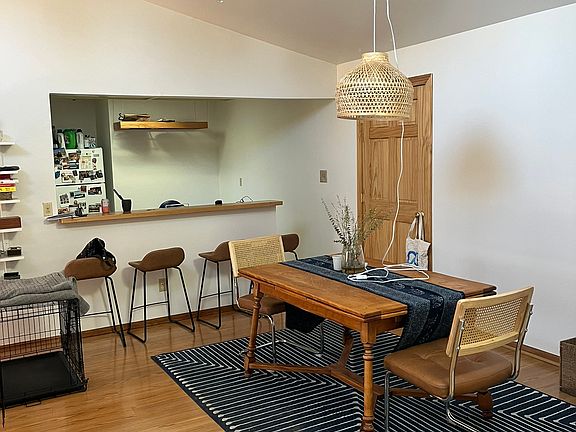 Dining area, vaulted ceiling, ceiling fan, and bar