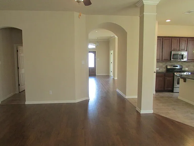 living-room and kitchen on the right, guest bathroom and utility room through the door on the left in the image
