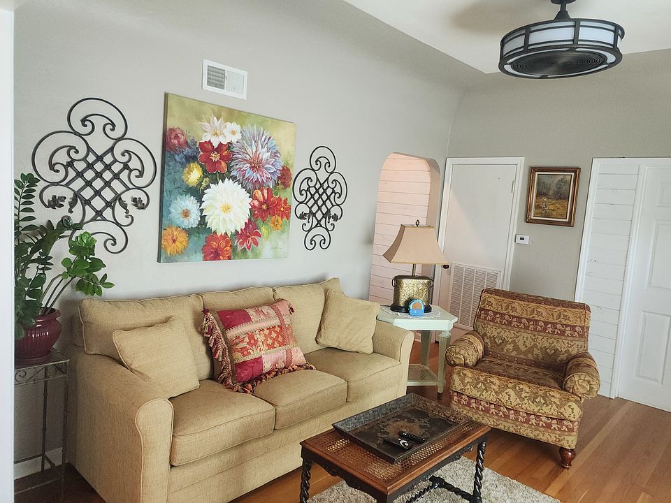 The living room is comfortably furnished with bright colors and a sofa bed for guests