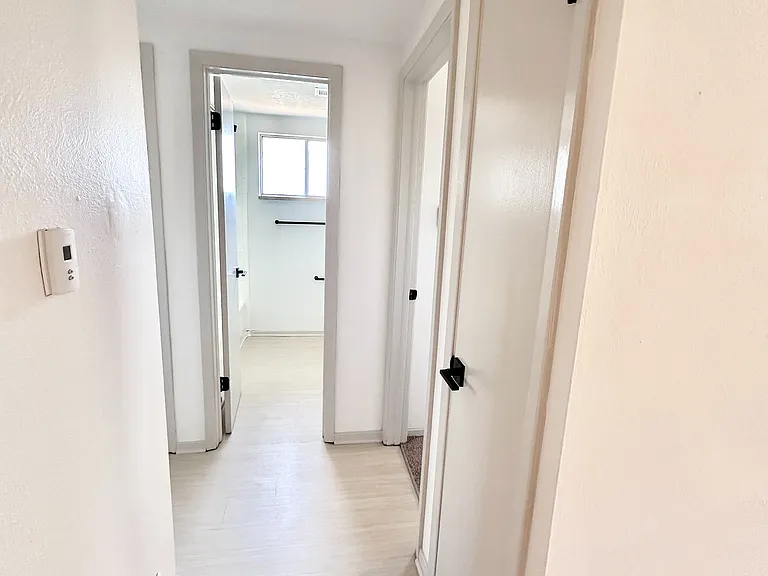 Bright and inviting hallway with modern doors in a contemporary apartment, featuring sleek finishes and light wood flooring.